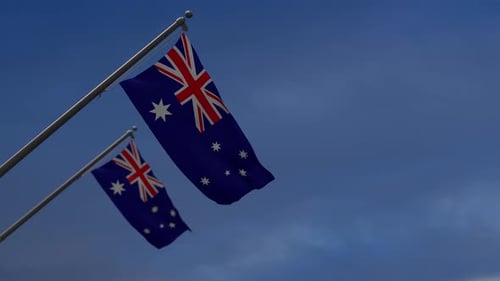 Two Realistic Australian Flags Waving Against Blue Sky