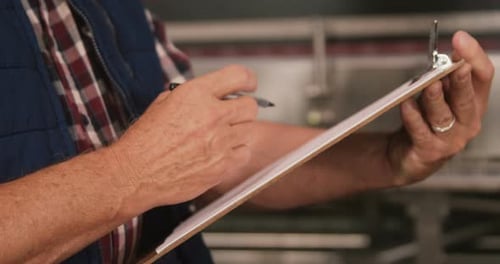 Man Writing on Clipboard, Close Up Shot