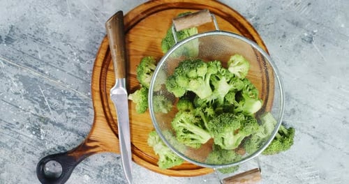 Overhead Shot of Broccoli in Strainer on Cutting Board