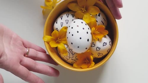 Decorated Easter Eggs with Spring Flowers in Bowl