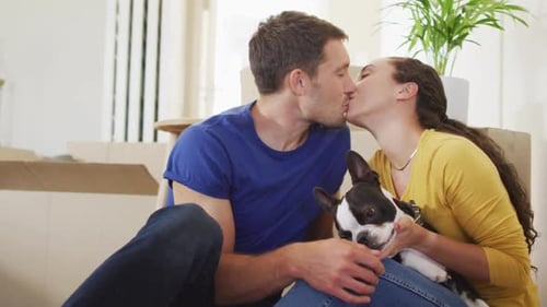 Loving Couple Kissing with Dog in New Home