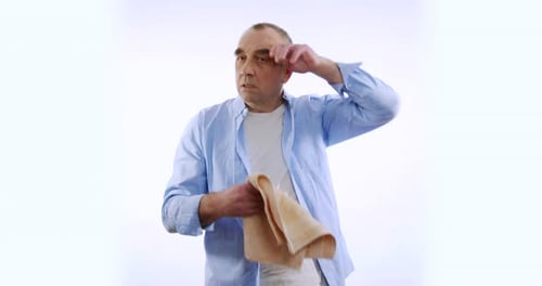 Man in Casual T-shirt Sweatingwipes His Forehead with Sweat. Isolated on White Background.