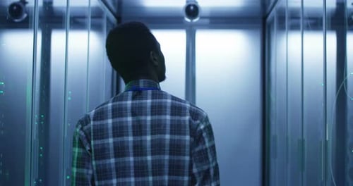 Young Adult Walks Through Modern Server Room