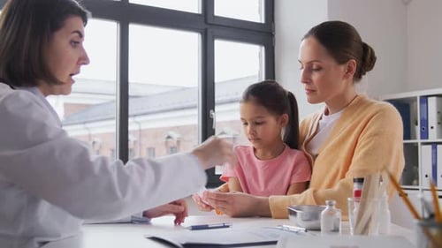 Mother with Little Daughter and Doctor at Clinic