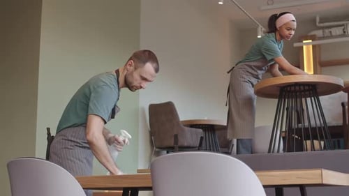 Employees Cleaning Tables in a Restaurant