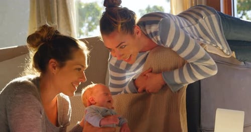 Two Women Admiring a Newborn Baby at Home