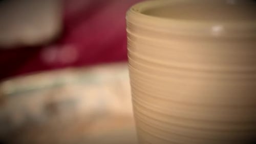 Les pots en argile brute se dressent et tournent le tour de potier dans l'atelier du potier Fermer