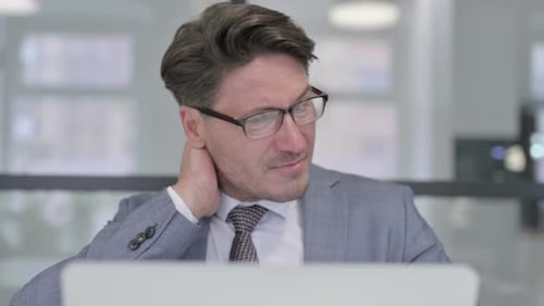 Close Up of Middle Aged Businessman with Laptop having Neck Pain