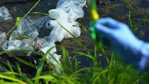 Hand Holding Sample in Test Tube With Biohazard Sign, Water From Polluted Lake