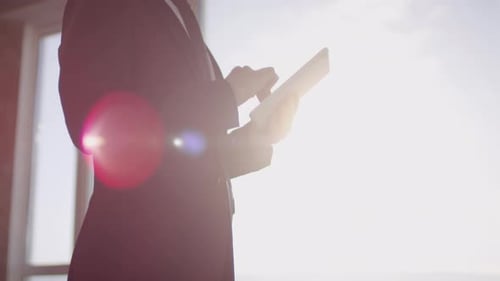 Unkenntlicher Geschäftsmann benutzt Tablet an sonnigem Tag