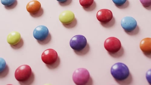 Video of colourful lentils on pink background