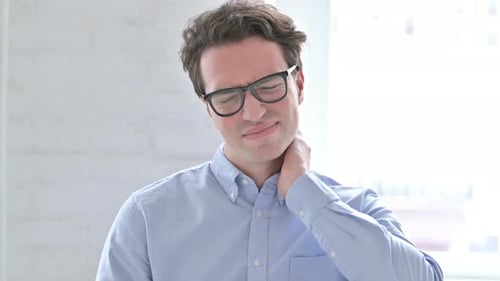 Young Man Rubbing his Neck in Pain