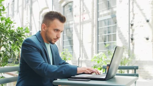 Young successful caucasian businessman works outdoor
