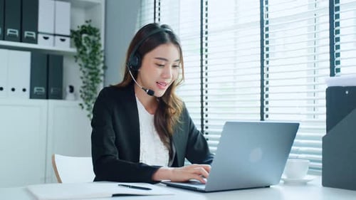Asian business female call center in formal wear talk to customer working in office workplace.