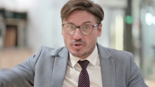 Assertive Businessman Pointing and Speaking
