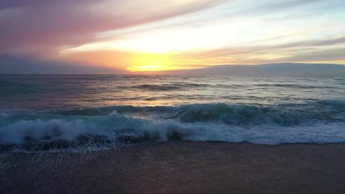 Vagues de mer sur un coucher de soleil lumineux et juteux filmées au-dessus Drone