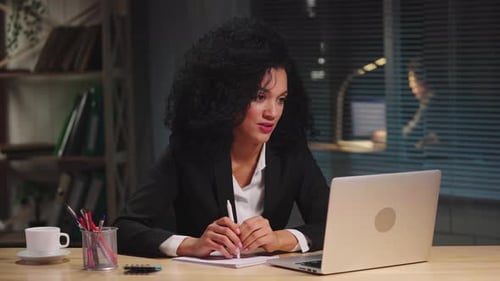 Woman Attends Video Conference at Her Desk