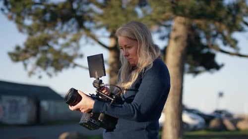 Woman Holding Professional Video Camera Outdoors