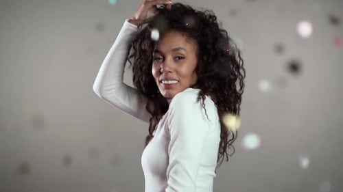 Young Woman Dancing as Confetti Falls