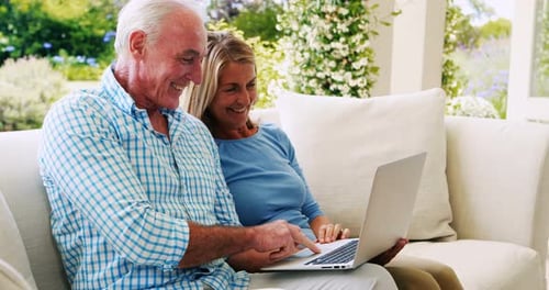 Senior Couple Using Laptop Together Outdoors