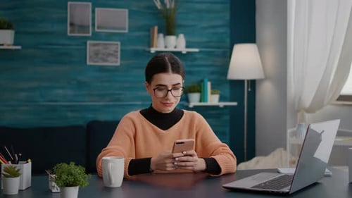 Female Student Browsing Internet on Smartphone at Home