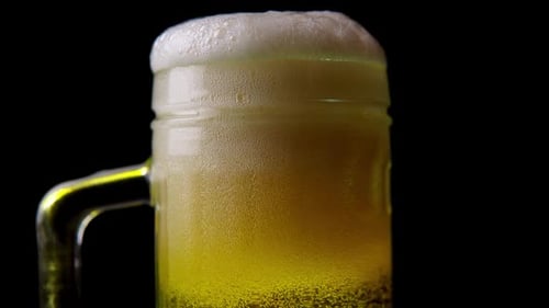 Beer Being Poured into a Clear Glass Mug
