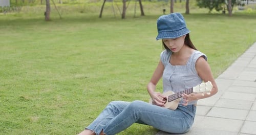 Woman playing ukulele at city