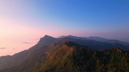 clouds above the valley and the mountains in the background. 4K Aerial video
