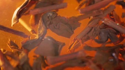 Close-up, Tea Leaves Float in Boiling Water. Tea Leaves Are Brewed. Herbal Tea in a Glass.