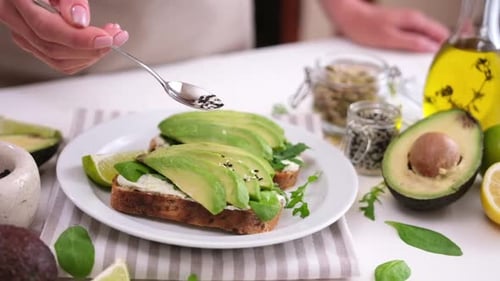 Preparing Avocado Toast with Fresh Green Toppings