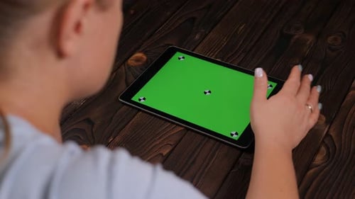 Closeup of a Young Woman Holding a Tablet with a Green Screen
