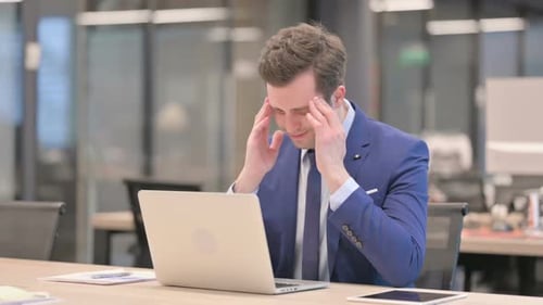 Businessman Working at Laptop Suffering from Headache