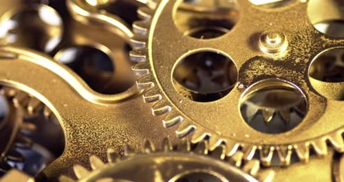 Rotating Gold Gears Working Together in Clockwise Motion