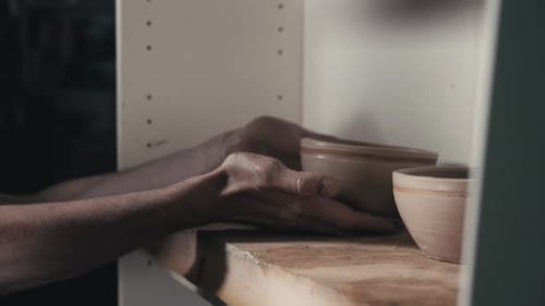 Mains du maître potier et vase d'argile sur le tour du potier en gros plan