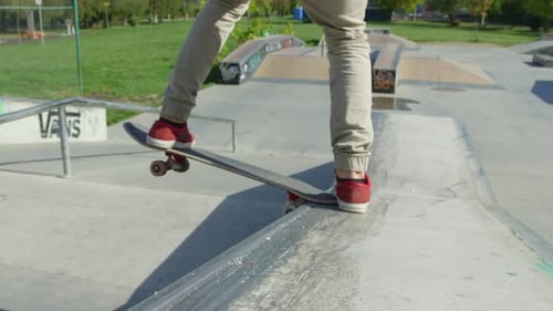 Teen Does Skateboard Trick at Urban Skatepark
