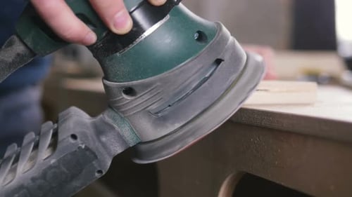 Worker Grinds the Wood of Angular Grinding Machine