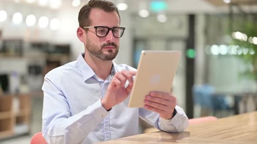 Seriöser Geschäftsmann nutzt Tablet im Büro