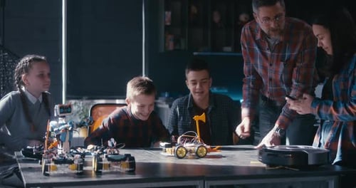 Teacher Explains Robotics Project to Eager Students