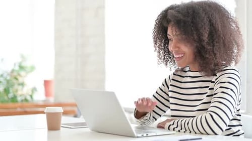 Woman Video Conferencing on Laptop at Desk