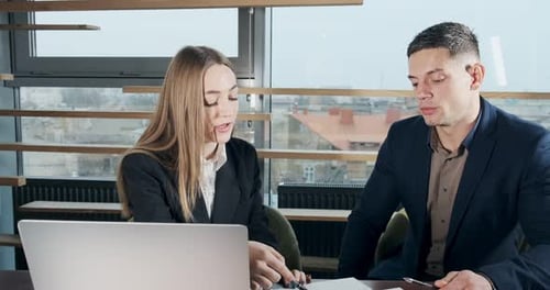 Man and a Woman Discussing Work in the Brightly Lit Modern Office. Concerned Male and Female Working