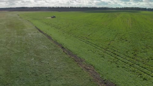 Tractor Working in Green Farmland Aerial Shot