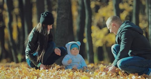 Father Mother and Son Throw Autumn Leaves in the Forest