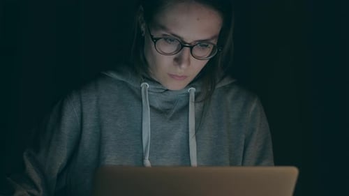 Brunette Girl Working on Notebook in the Night at Home