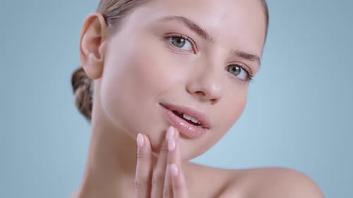 Young Woman Touches Face in Beauty Portrait