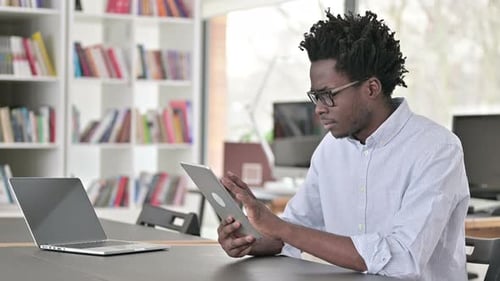 Young Adult Using Tablet in Modern Workplace