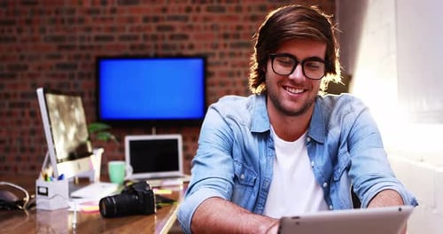 Young Man Using Tablet at Creative Workplace