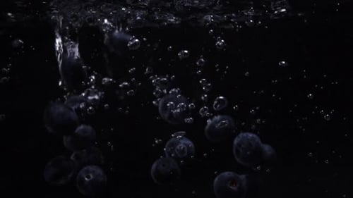 Tasty Fresh Blueberries Falling Into Water. Blue Wildberries in Slow Motion Underwater. Food Video