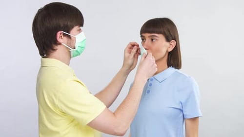 Man Puts Surgical Mask On Woman For Protection