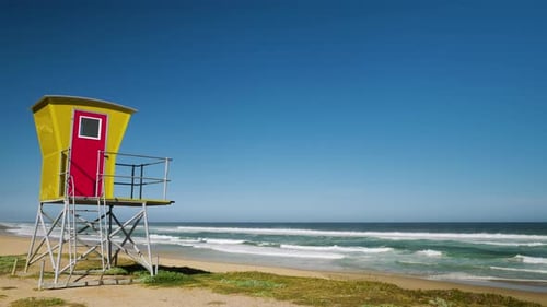 Colourful lifeguard tower overlooking beach - panning shot