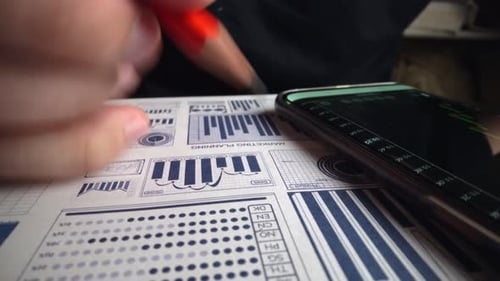 Accountant Analyzing Business Marketing Data on Paper Dashboard at Office Table